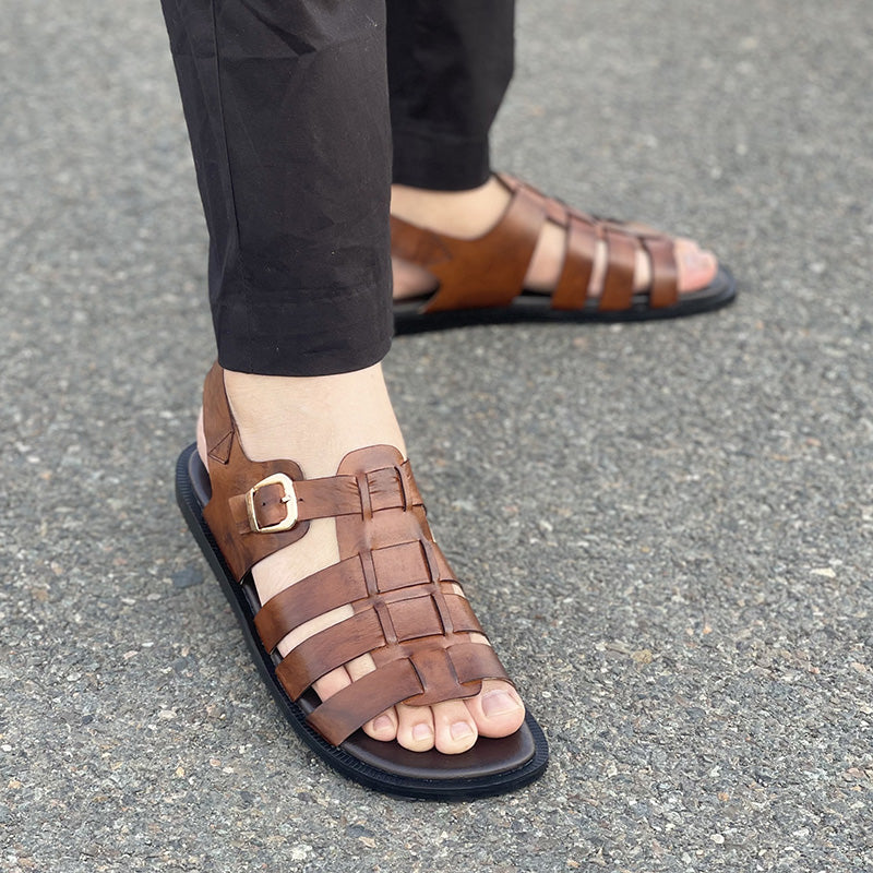 Close-up of men's brown handmade leather strappy sandals with gold buckle