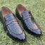 Black crocodile embossed leather loafers for men on green grass