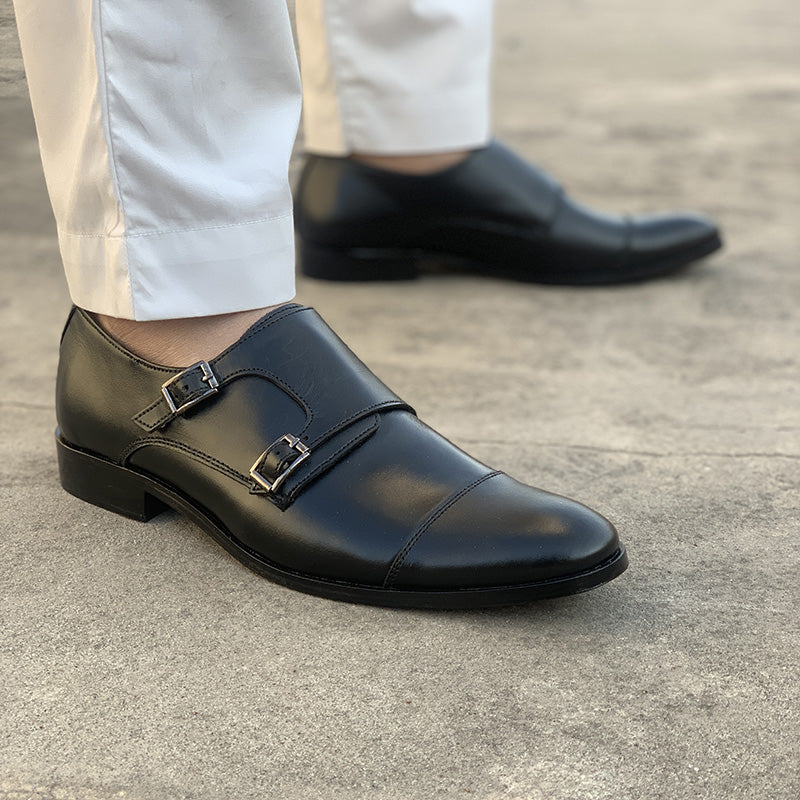 Man wearing handmade black leather double monk strap formal shoes with white trousers