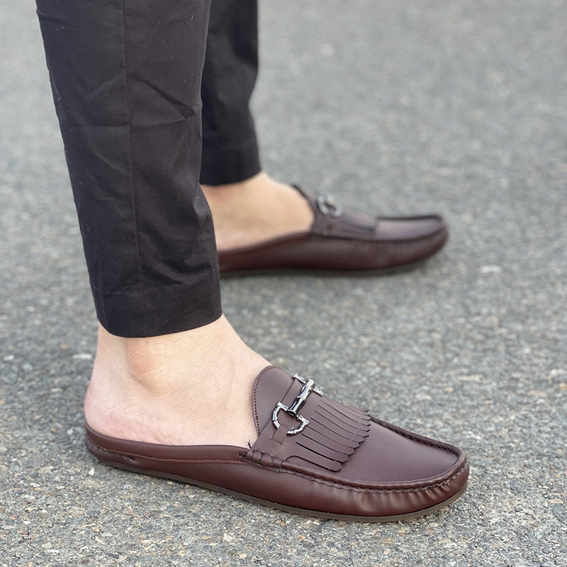 Man wearing brown leather handmade mules with silver buckle and tassels
