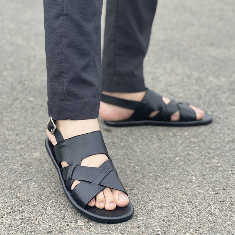 Man wearing handmade black leather strappy sandals with ankle buckles