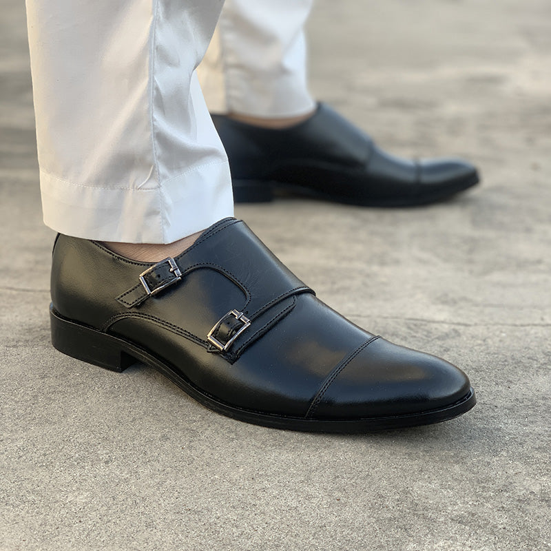 Man wearing black leather double monk strap formal shoes with white trousers