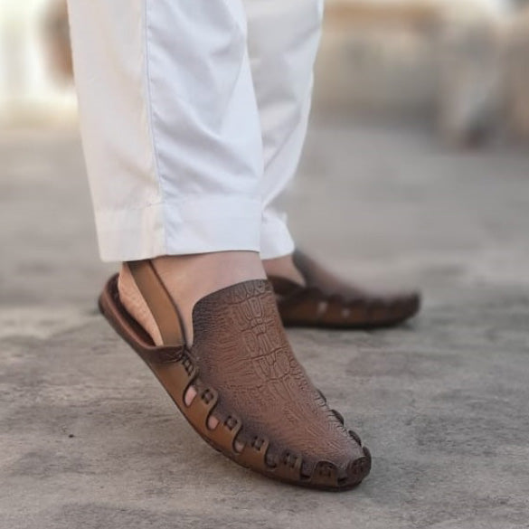 Man wearing brown crocodile-texture leather Peshawari Chappals with white trousers